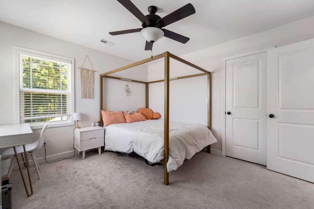a bedroom with a canopy bed and a ceiling fan