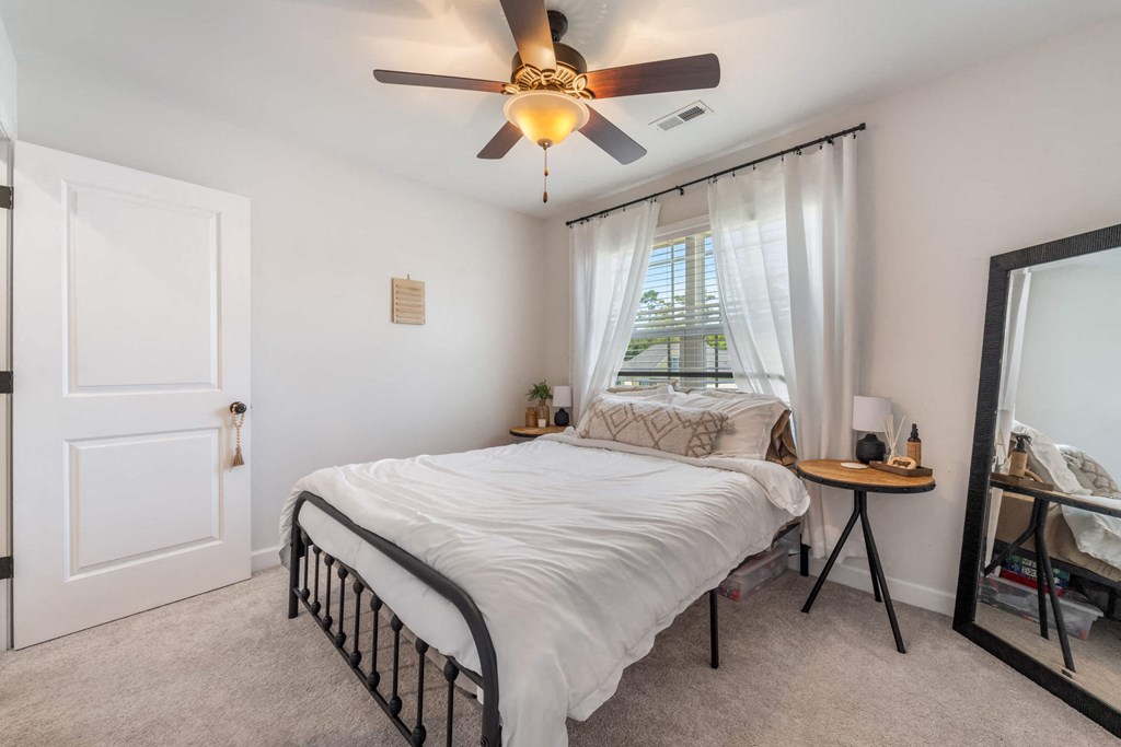 a bedroom with a bed and a ceiling fan