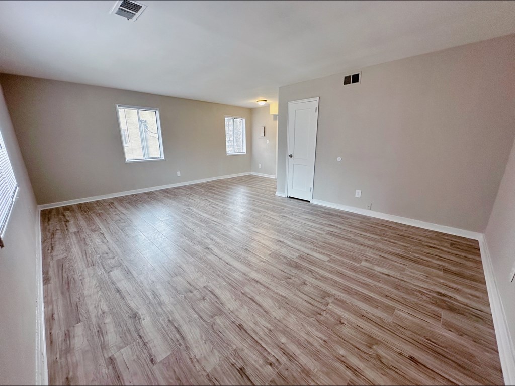 A room with wooden flooring and white walls.