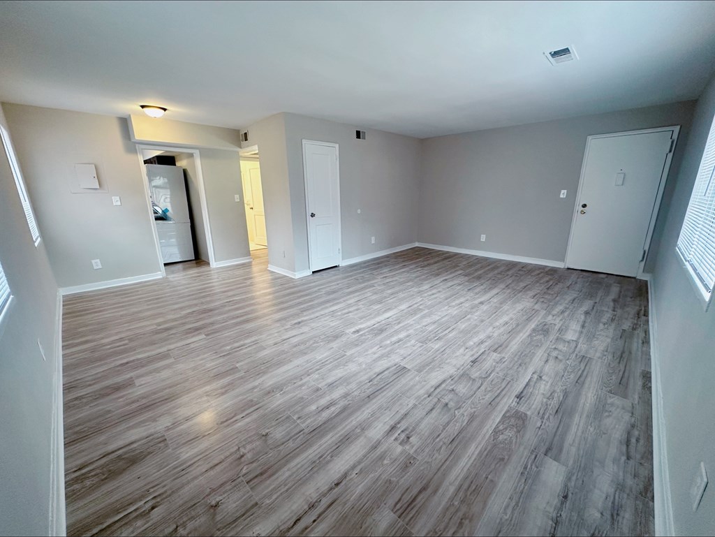 A room with wooden flooring and white walls.