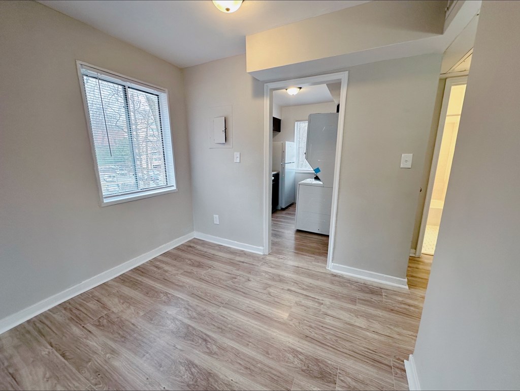 A room with a window and a door leading to another room.