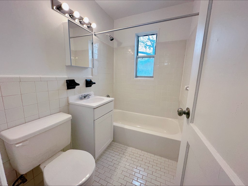 A white bathroom with a toilet, sink, and bathtub.