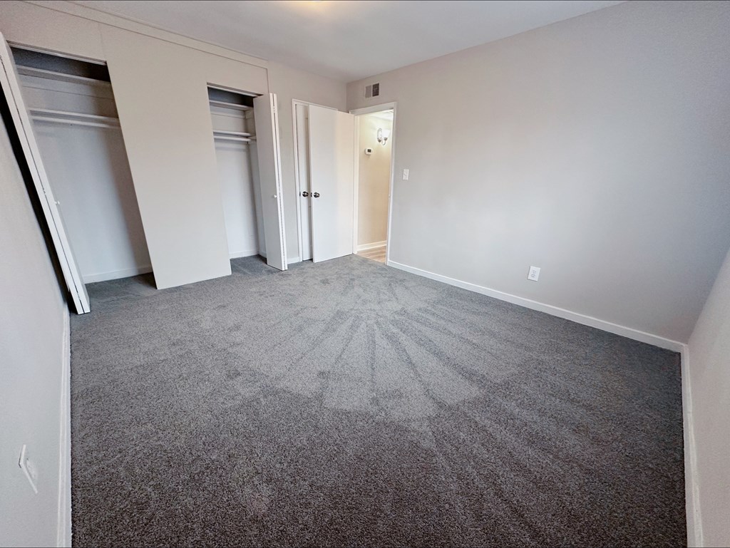 A room with a grey carpet and white walls.