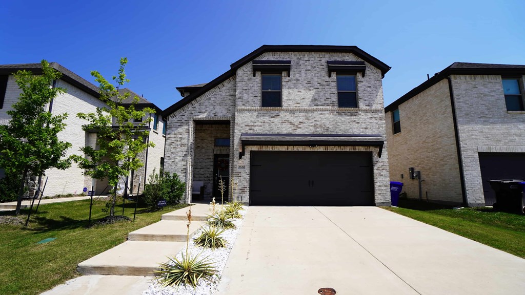the front of a house with a driveway and a garage door