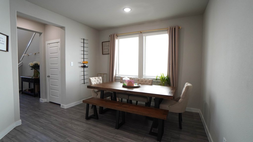 a dining room with a wooden table and two windows