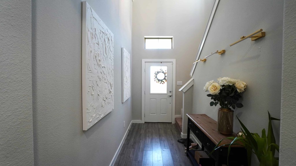 a long hallway with white walls and a white door    and a v
