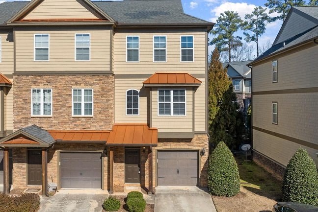 a two story house with two garage doors