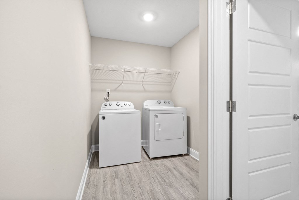 an empty laundry room with two washes and a dryer