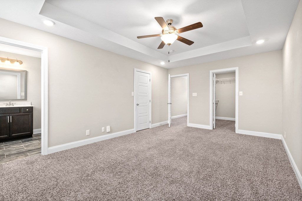 an empty living room with a ceiling fan