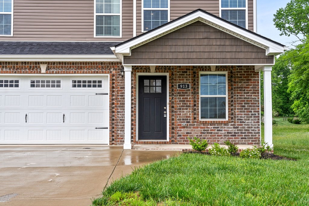 a home with a black door and a white garage door
