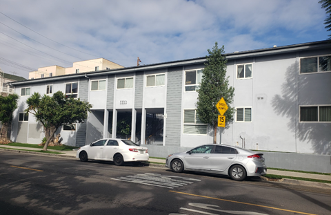 a white building with two cars parked in front of it