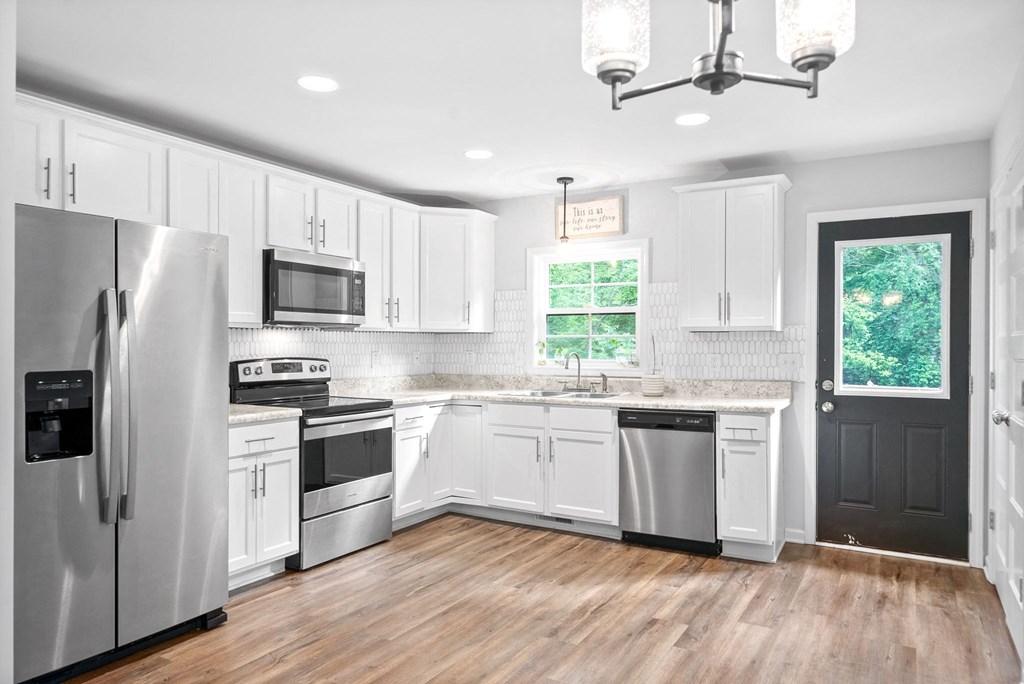 a kitchen with white cabinets and stainless steel appliances