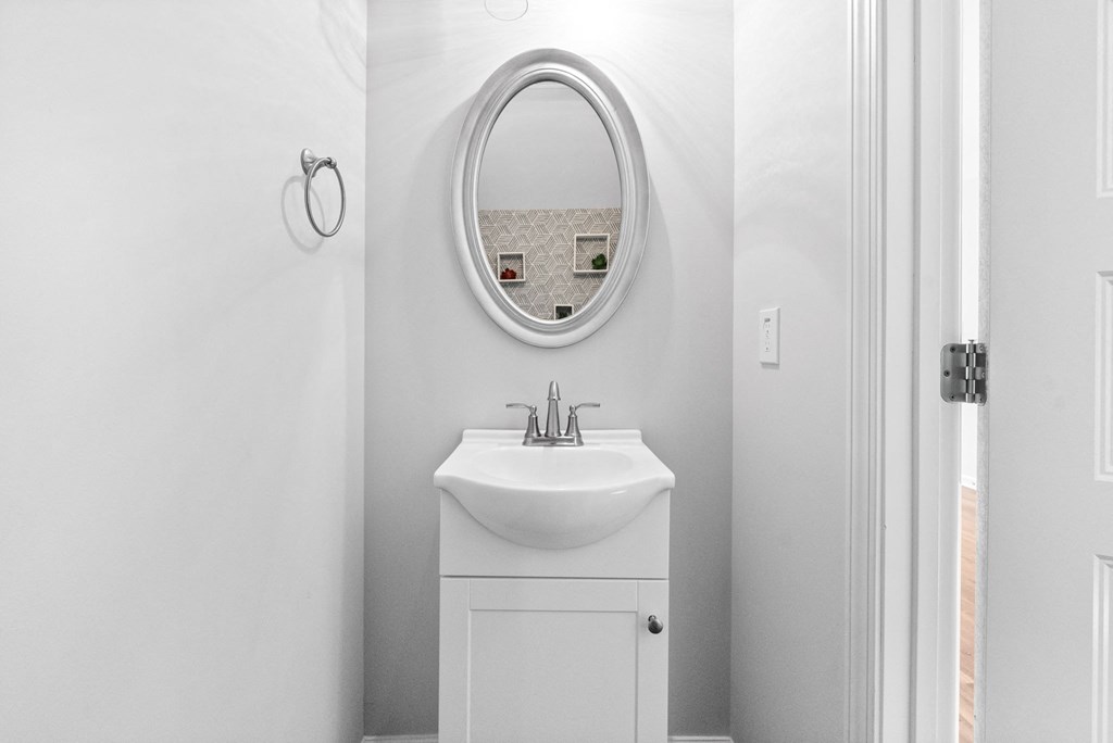 a white bathroom with a sink and a mirror