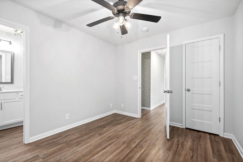 a living room with white walls and a ceiling fan