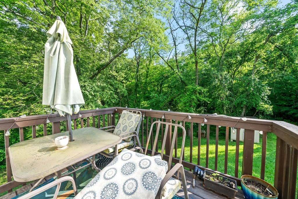 a backyard deck with a table and chairs and an umbrella