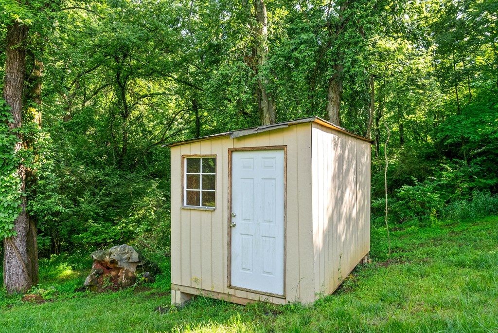 a small wooden outhouse in the woods