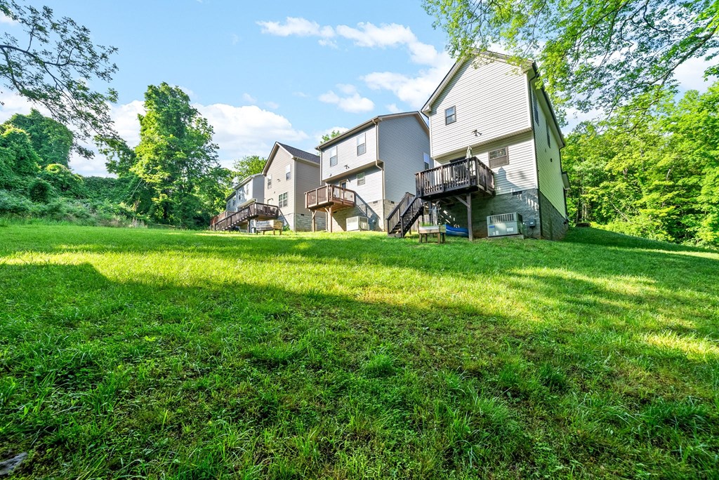 a group of houses on a hill with grass and trees