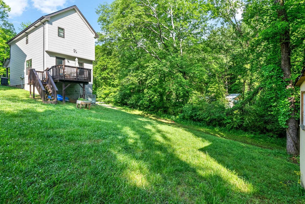 a house in the woods with a yard and a deck