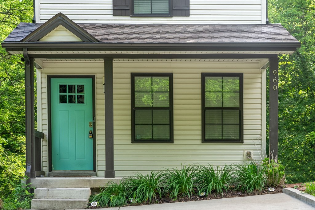 a small yellow house with a green door