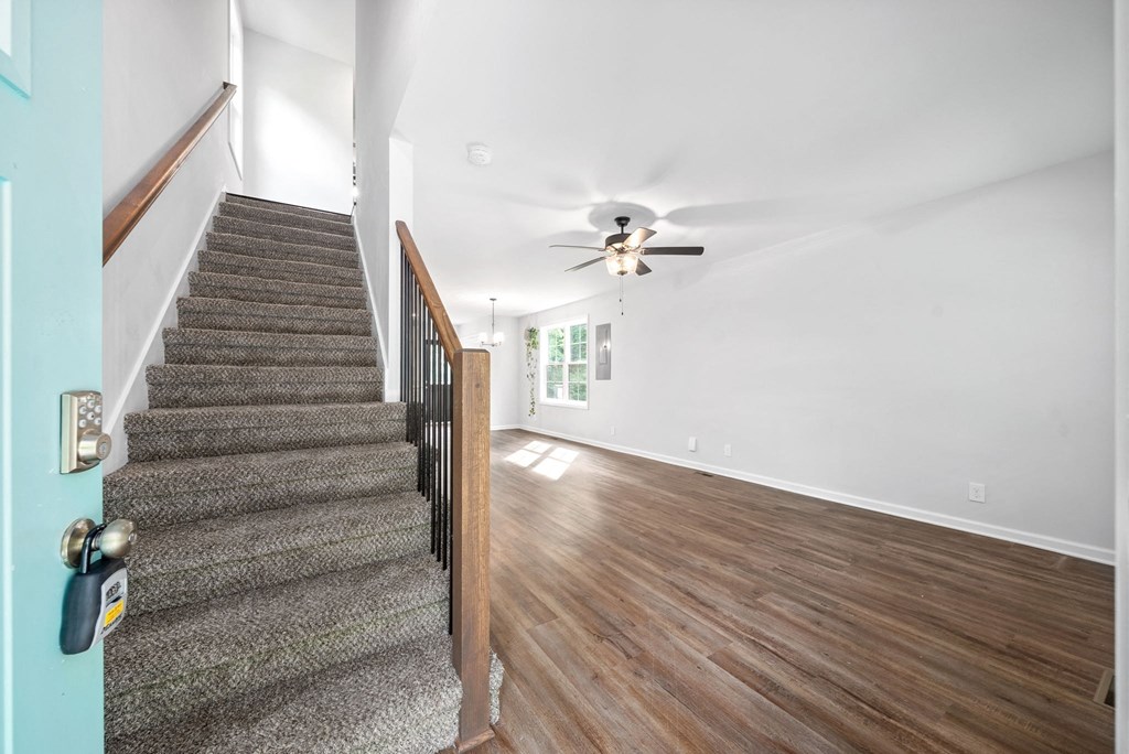the entryway of a house with stairs and a ceiling fan