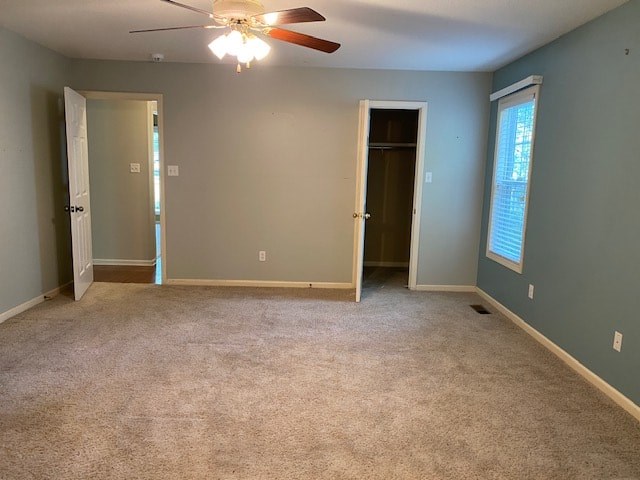 an empty room with a ceiling fan and a door