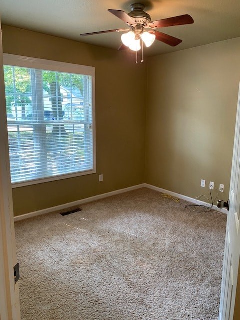 an empty room with a ceiling fan and a window
