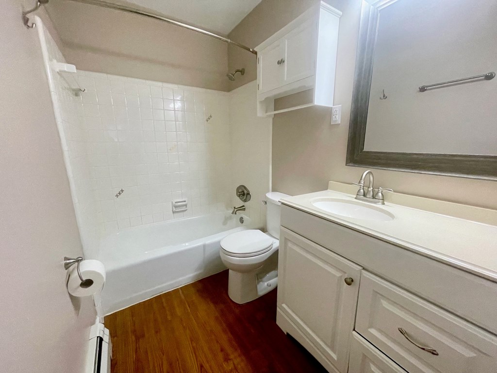 a bathroom with a toilet sink and tub and a mirror