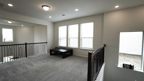 the upstairs bonus room has large windows and a seating area