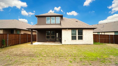 the front of a house with a yard and a fence