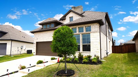 a house with a garage and a tree in the yard