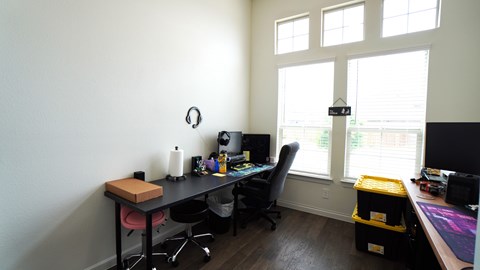 a home office with a desk and a window