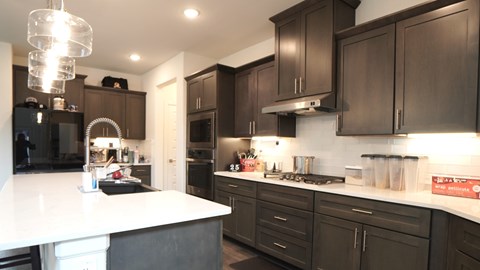 a kitchen with black cabinets and a white counter top