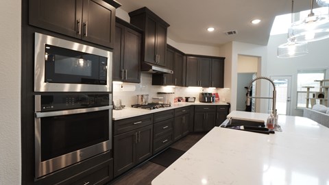 a black and white kitchen with stainless steel appliances and white counter tops