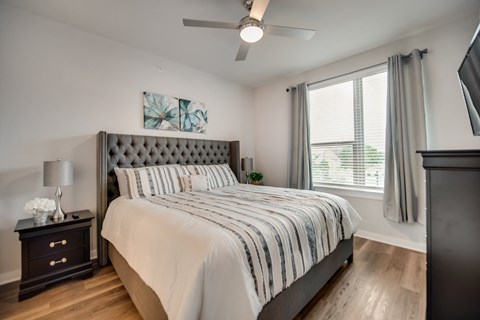a bedroom with a large bed and a ceiling fan