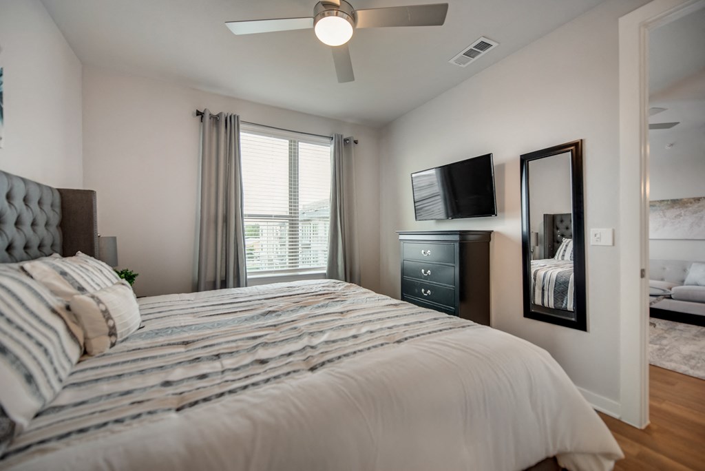 a bedroom with a large bed and a ceiling fan