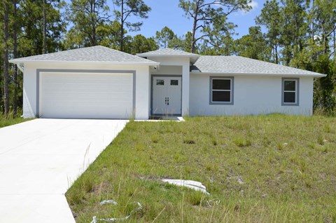 a white house with a driveway and a garage door