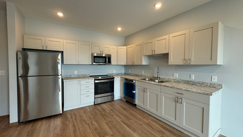 a kitchen with white cabinets and stainless steel appliances