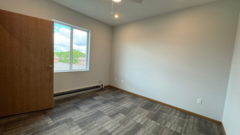an empty living room with wood flooring and a window
