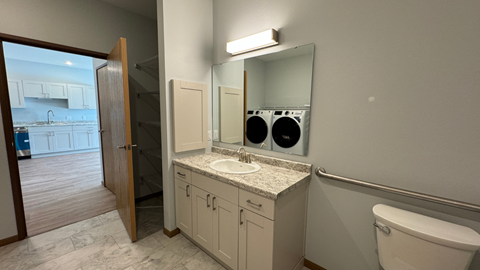 a bathroom with a sink and a mirror and a laundry room