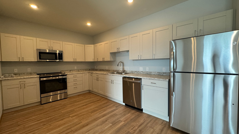 a kitchen with white cabinets and stainless steel appliances