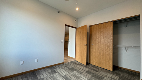 an empty room with two doors and a closet