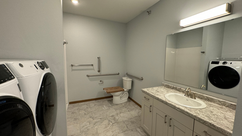 a washer and dryer in a bathroom with a sink and a toilet