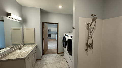 a laundry room with a washer and dryer and a sink and a mirror