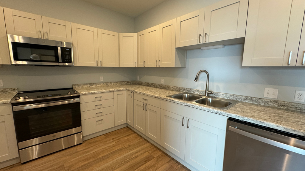 a kitchen with white cabinets and stainless steel appliances
