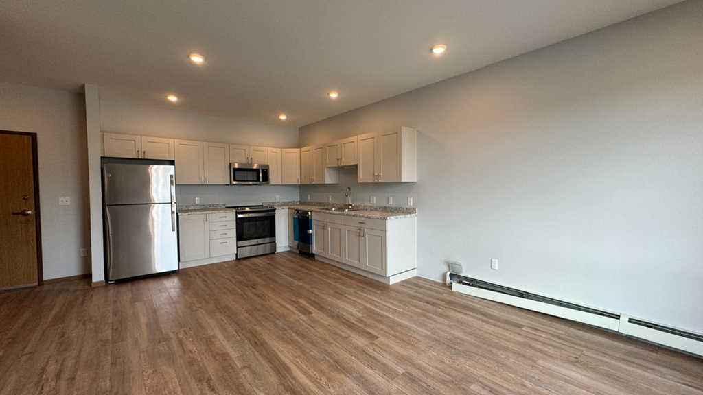 a kitchen with white cabinets and a stainless steel refrigerator
