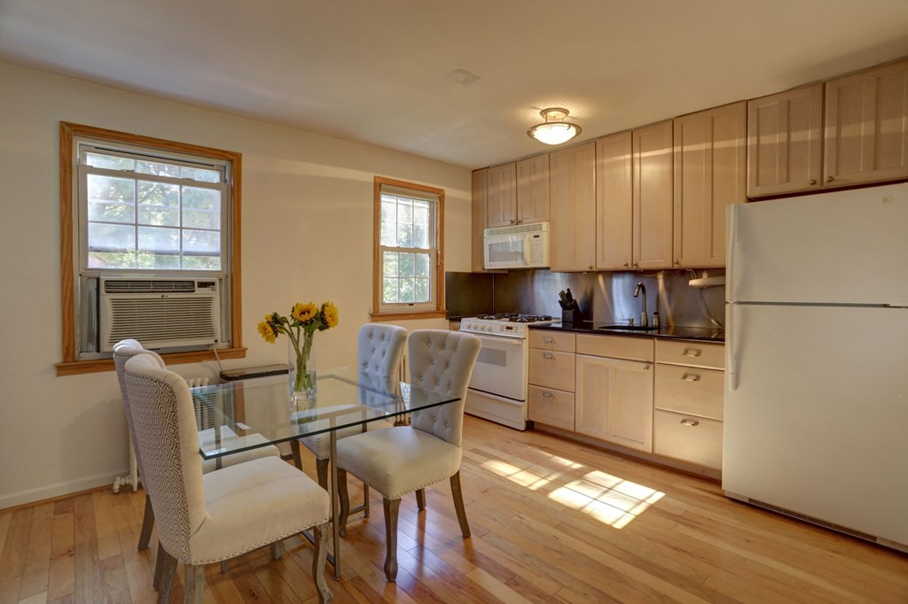 a kitchen and dining room with a glass table and chairs