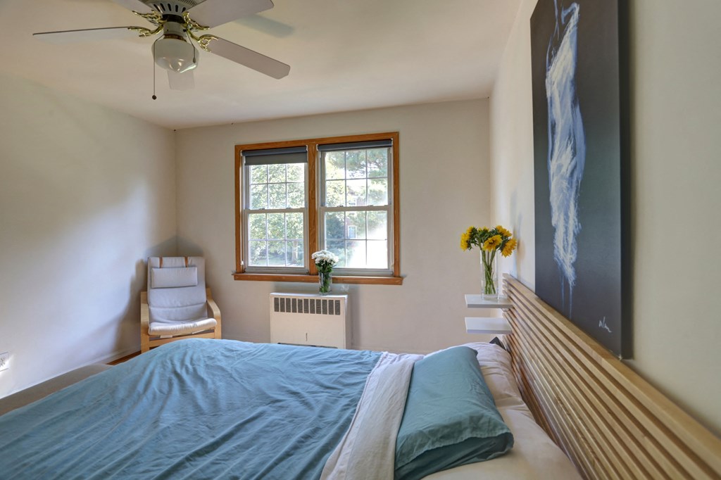 a bedroom with a bed and a ceiling fan