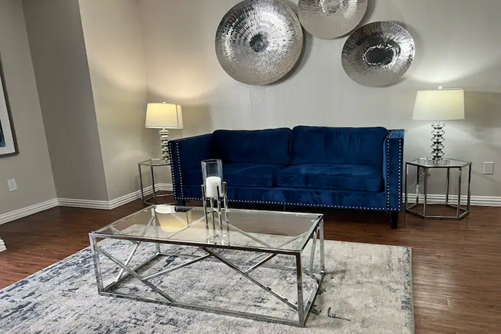 a living room with a blue couch and a glass coffee table
