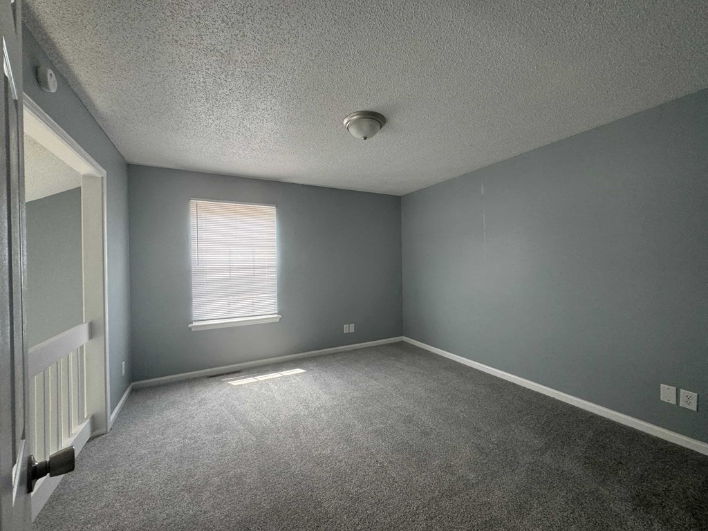 an empty room with blue walls and a window