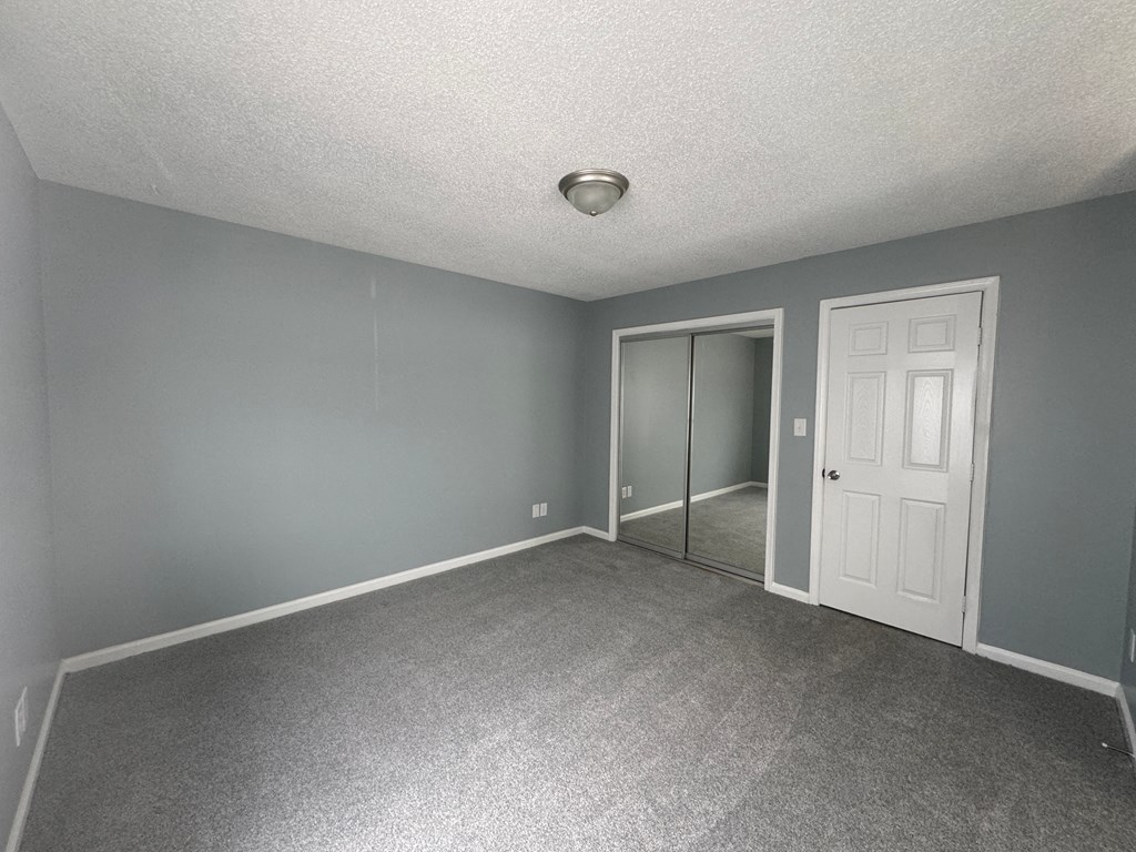 an empty room with gray walls and a white door